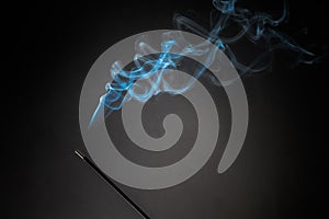 Smoking incense stick with smoke going up on Black Background. Pure relaxation theme, smoke steam, smoke waves, fog and mist