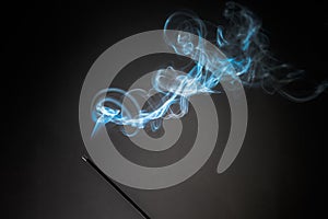 Smoking incense stick with smoke going up on Black Background. Pure relaxation theme, smoke steam, smoke waves, fog and mist
