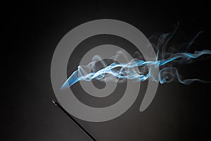 Smoking incense stick with smoke going up on Black Background. Pure relaxation theme, smoke steam, smoke waves, fog and mist