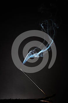 Smoking incense stick with smoke going up on Black Background. Pure relaxation theme, smoke steam, smoke waves, fog and mist