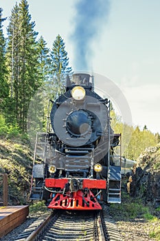 smoking locomotive with burning headlights and spotlight photo