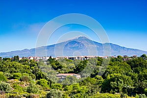 Smoking mount Etna above sicilian cities signs of an eruption