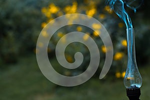 A smoking old kerosene lamp on a green grass. photo