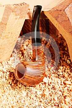 Smoking pipe leaning on wood