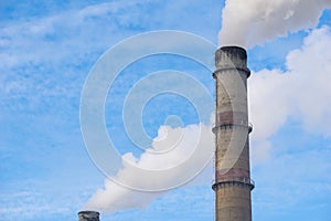 Smoking pipes from factories against a blue sky. Smoking factory chimney close-up. ecology