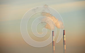 Smoking pipes of a heating plant against the background