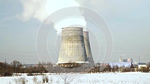Smoking pipes on manufacturing facility on winter landscape. Smoking chimney on industrial factory. Industrial pipes on
