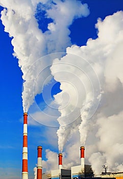 Smoking pipes of thermal power plant against blue sky