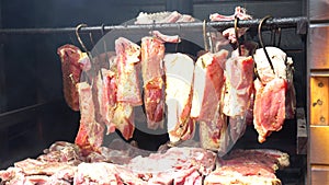 Smoking pork meat, bacon and sausages, food preparation process of cured pork meat delicacy smokehouse.
