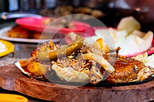 smoking sizzler shot with vegetables, meat, chicken cabbage and chilis placed on iron hot plate and served on a wooden