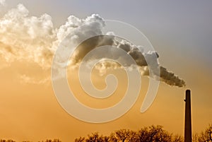 Smoking Smokestack Against Orange and Blue Sky