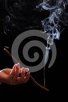 Smoking stick in the woman`s hand