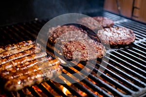 Smoky hamburger meat grilling for burgers. Fry on an open fire on the grill - bbq.Burgers and sausages Cooking Over