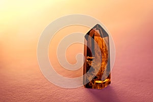 Smoky quartz crystal point with phantoms isolated on a pink background