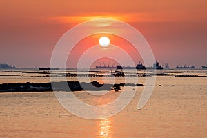 Smoky and soft sea water surface with small island named Koh Loy during sun set