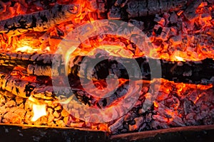 Smoldering embers of fire, live coals, burning charcoal in the background texture, closeup, glowing coal