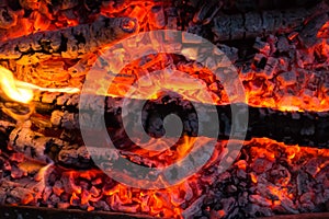 Smoldering embers of fire, live coals, burning charcoal in the background texture, closeup, glowing coal
