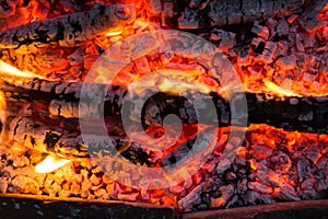 Smoldering embers of fire, live coals, burning charcoal in the background texture, closeup, glowing coal