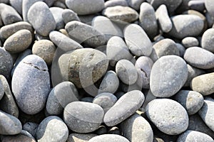 Smooth and beautiful pebbles on the beach in the sunlight close up