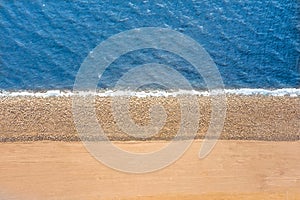 Smooth border between sea and land. Stones mound of sand and water, top aerila view