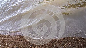 Smooth and constant waves in the clear waters of the lake. Waves crashing on the beach.