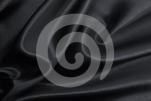 Smooth elegant black silk or satin texture as abstract background. Luxurious background design photo