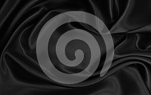Smooth elegant black silk or satin texture as abstract background. Luxurious background design photo