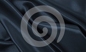 Smooth elegant dark grey silk or satin luxury cloth texture as abstract background. Luxurious background design