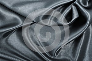 Smooth elegant dark grey silk or satin texture as abstract background. Luxurious background design