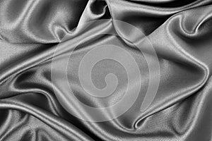 Smooth elegant dark grey silk or satin texture as abstract background. Luxurious background design