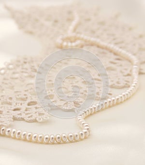 Smooth elegant golden silk or satin with pearls and lace as wedding background. In Sepia toned. Retro style