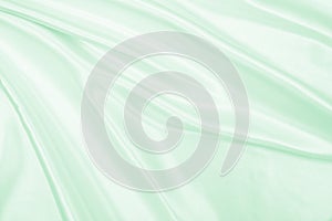 Smooth elegant green silk or satin luxury cloth texture as abstract background. Luxurious background design