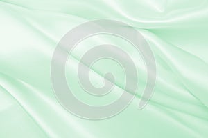 Smooth elegant green silk or satin luxury cloth texture as abstract background. Luxurious background design