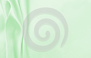 Smooth elegant green silk or satin luxury cloth texture as abstract background. Luxurious background design