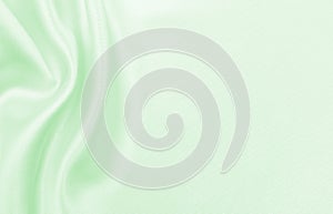 Smooth elegant green silk or satin luxury cloth texture as abstract background. Luxurious background design