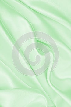 Smooth elegant green silk or satin luxury cloth texture as abstract background. Luxurious background design