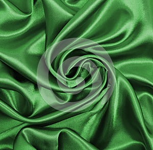 Smooth elegant green silk or satin luxury cloth texture as abstract background. Luxurious background design