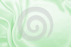 Smooth elegant green silk or satin luxury cloth texture as abstract background. Luxurious background design