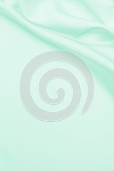 Smooth elegant green silk or satin luxury cloth texture as abstract background. Luxurious background design