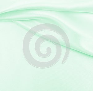 Smooth elegant green silk or satin luxury cloth texture as abstract background. Luxurious background design