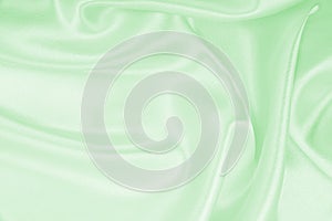 Smooth elegant green silk or satin luxury cloth texture as abstract background. Luxurious background design