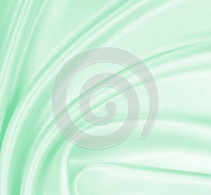 Smooth elegant green silk or satin luxury cloth texture as abstract background. Luxurious background design