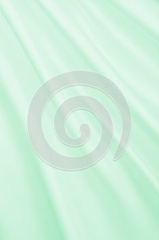 Smooth elegant green silk or satin luxury cloth texture as abstract background. Luxurious background design