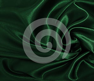 Smooth elegant green silk or satin luxury cloth texture as abstract background. Luxurious background design