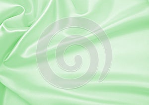 Smooth elegant green silk or satin luxury cloth texture as abstract background. Luxurious background design