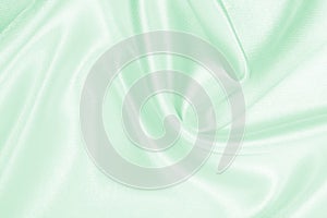 Smooth elegant green silk or satin luxury cloth texture as abstract background. Luxurious background design