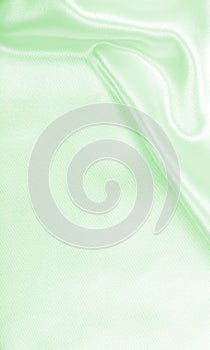 Smooth elegant green silk or satin luxury cloth texture as abstract background. Luxurious background design