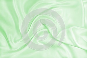 Smooth elegant green silk or satin luxury cloth texture as abstract background. Luxurious background design