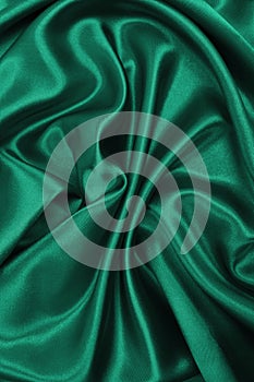 Smooth elegant green silk or satin luxury cloth texture as abstract background. Luxurious background design