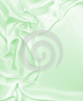 Smooth elegant green silk or satin luxury cloth texture as abstract background. Luxurious background design